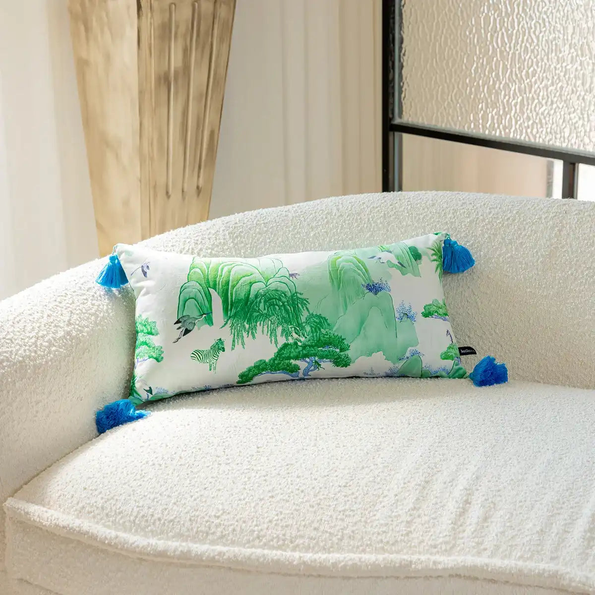 Artisan Chinoiserie garden print throw pillow with blue tassels on a cozy sofa.