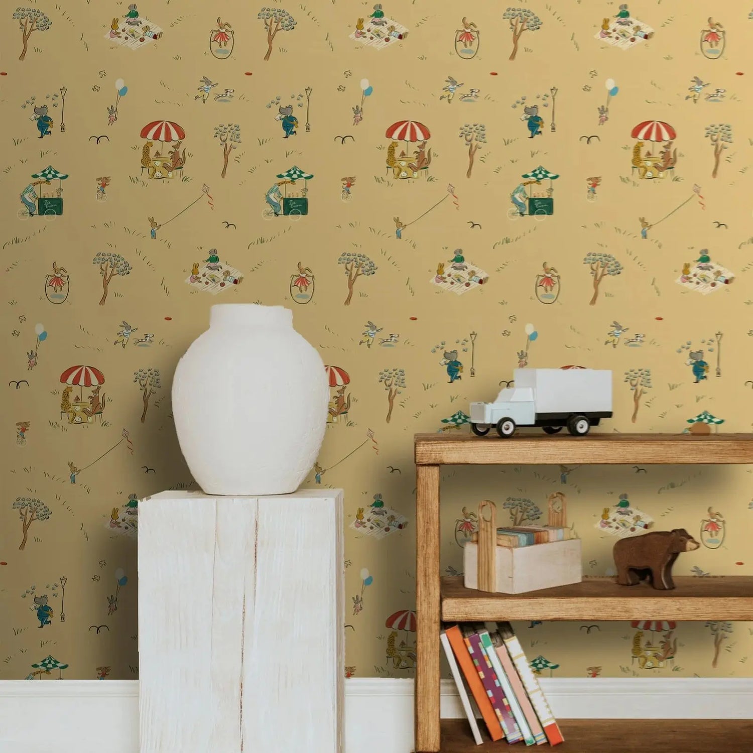 White vase on a white cabinet with a wooden shelf holding books and a bear figurine, against a patterned wallpaper.