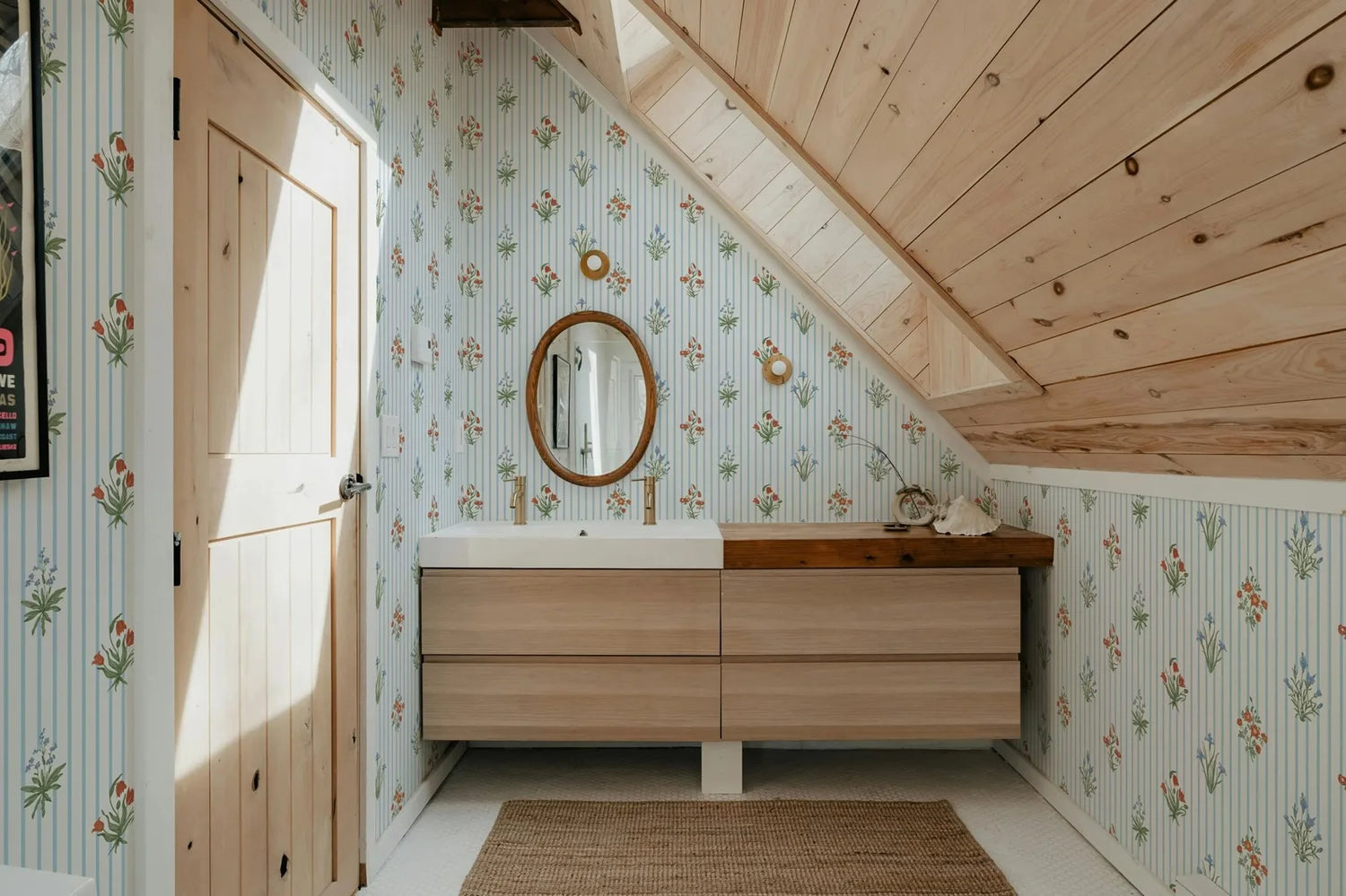 Bathroom with wooden vanity, floral wallpaper, and wooden ceiling.