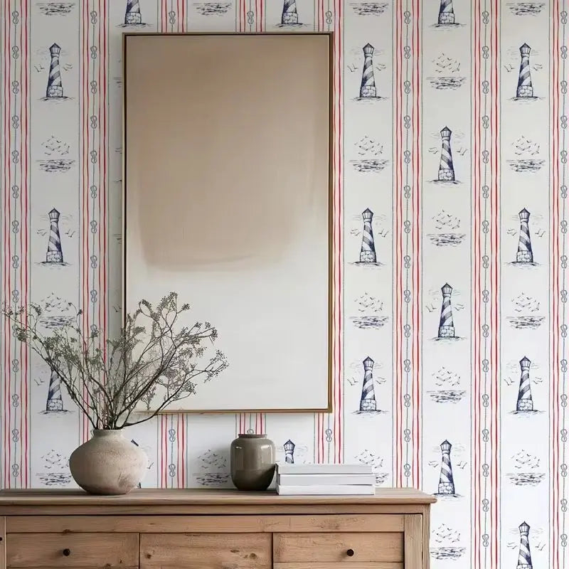 Wallpaper with lighthouse pattern, wooden dresser with decorative items, and a mirror.