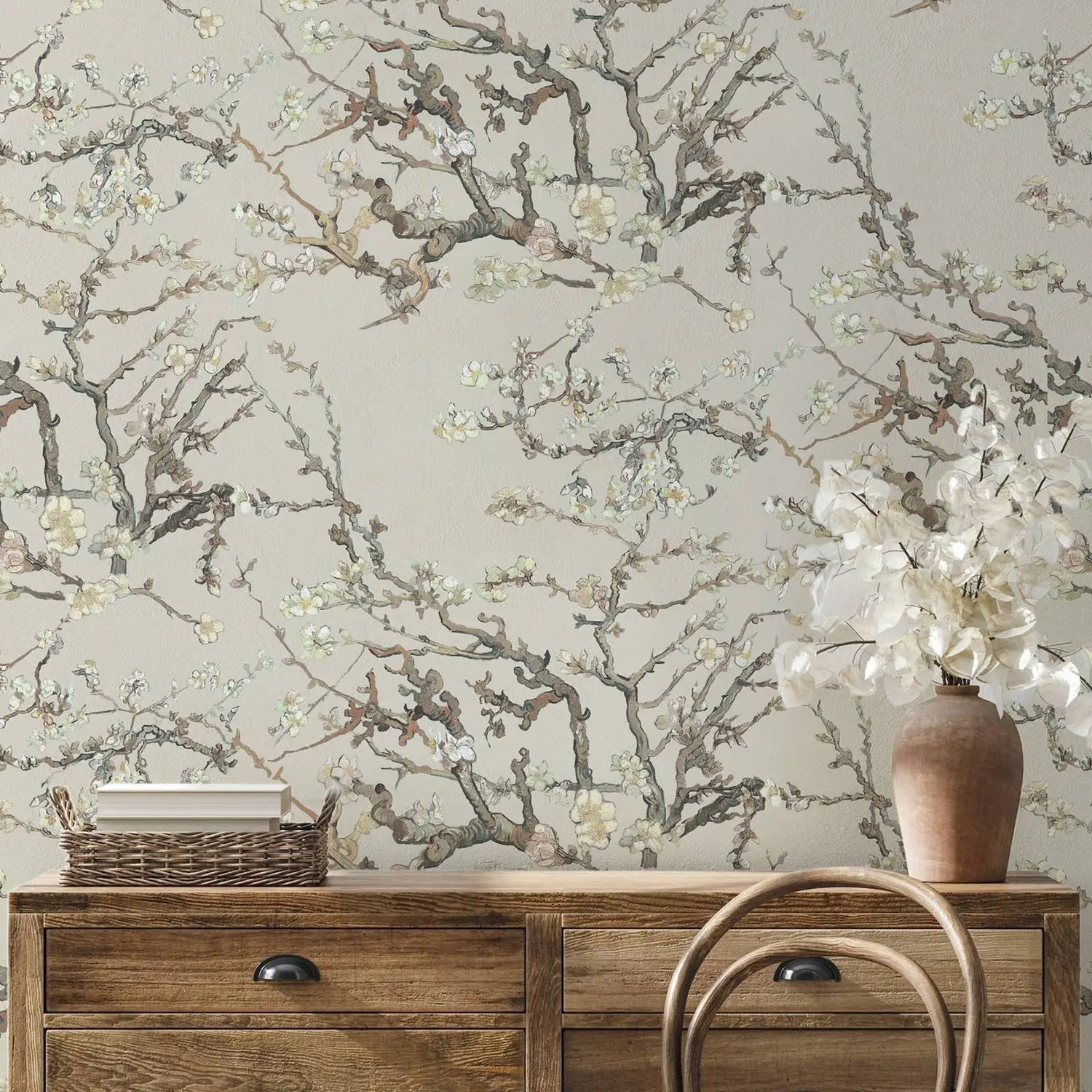 Wallpaper with floral branch design in a room with wooden furniture and decor items.