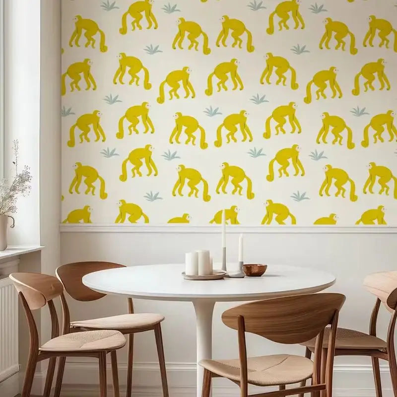 Dining room with a white table and wooden chairs, featuring a patterned wall with yellow monkey designs.