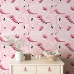 Flamingo patterned wallpaper with a table and decorative items in front