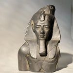 Statue of a pharaoh with a headdress on a neutral background