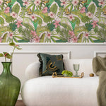Living room with tropical wallpaper, white sofa, and decorative items.