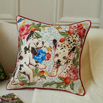 Decorative pillow with dalmatian dogs and flowers on a beige sofa.