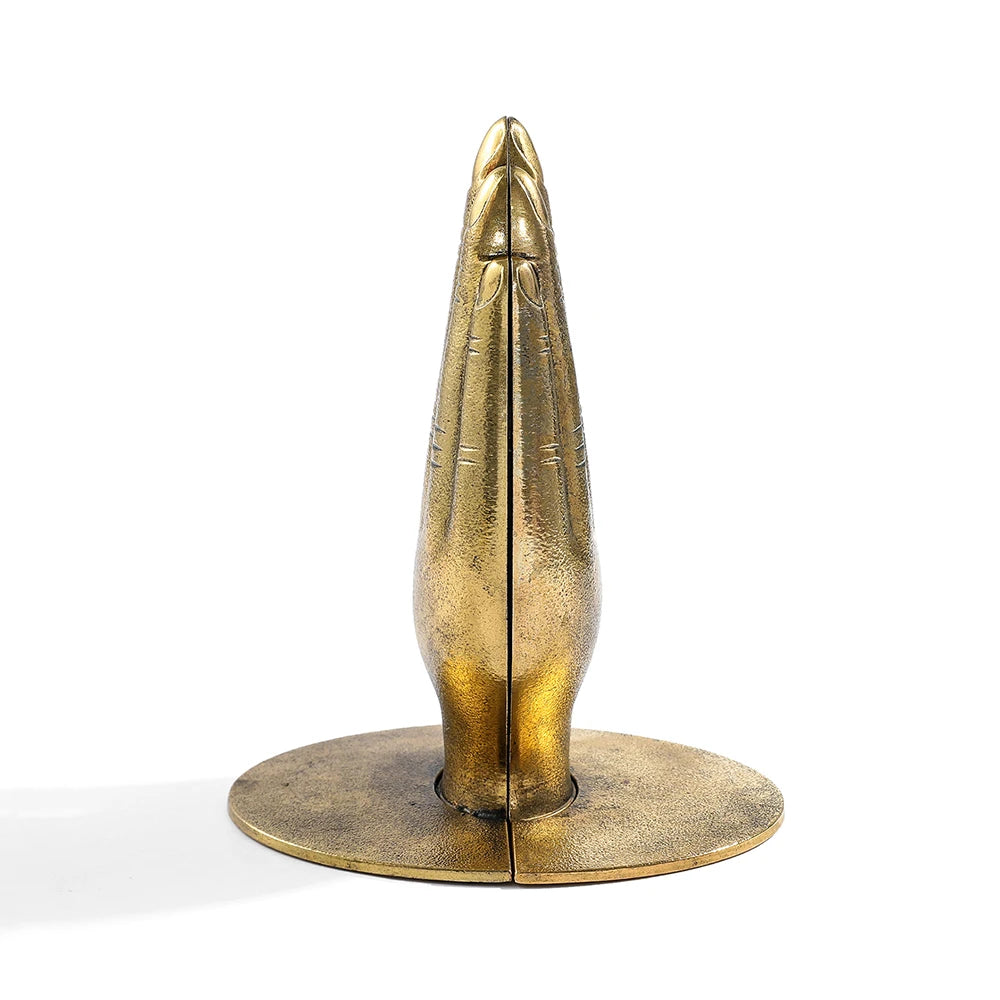 Bronze sculpture of a stylized face on a white background