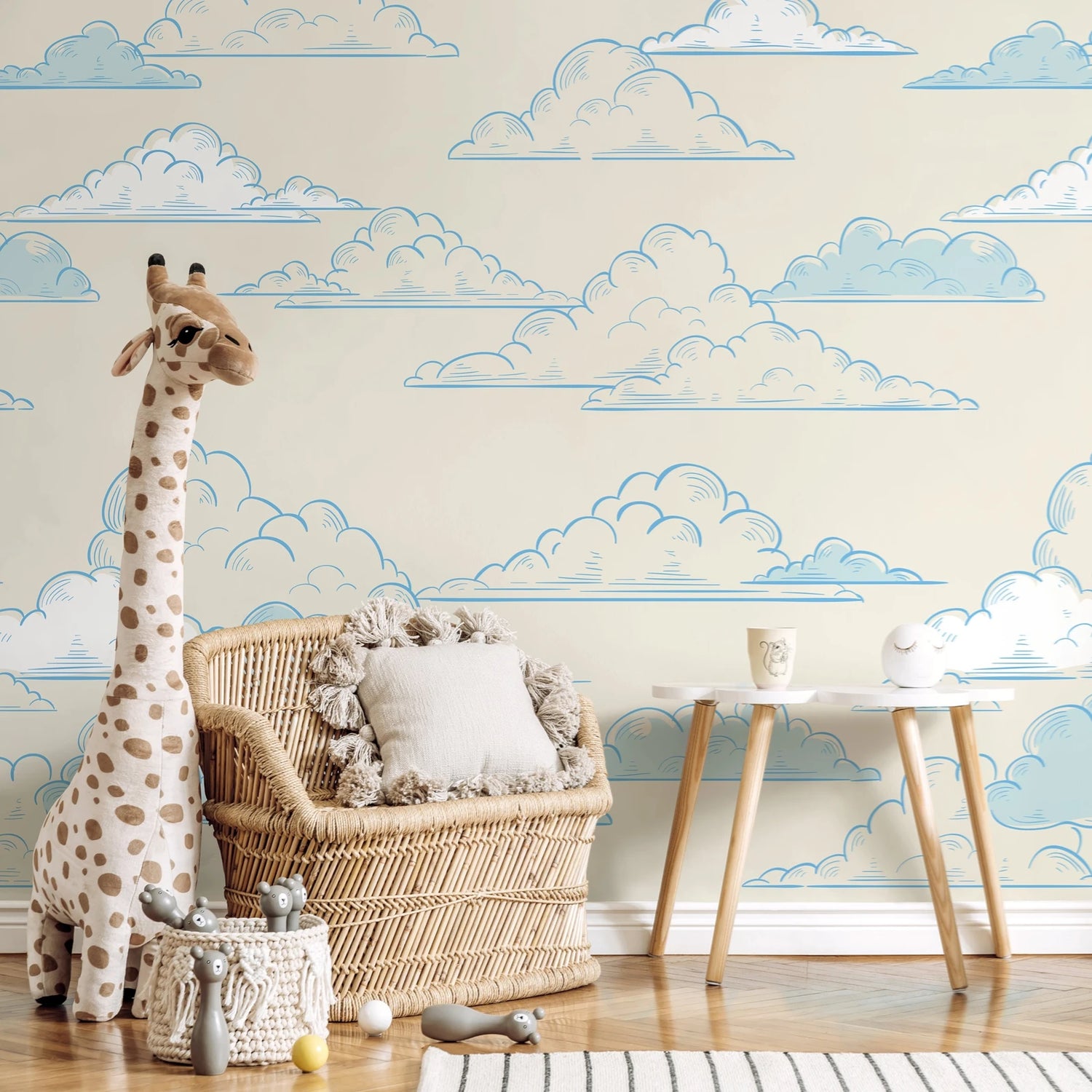 Children's room with cloud-patterned wallpaper, wicker chair, and stuffed giraffe.