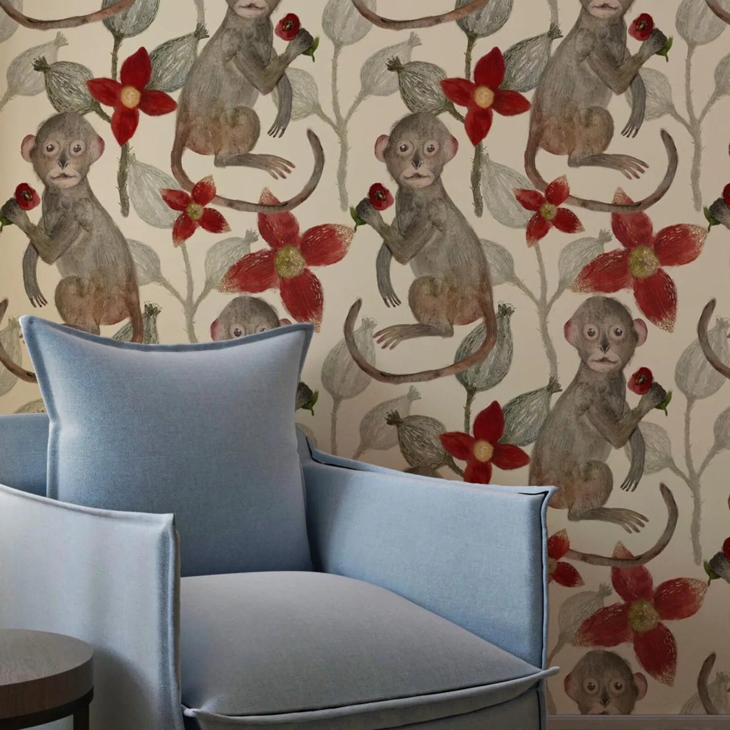 Decorative wallpaper with monkey and floral pattern next to a blue chair.