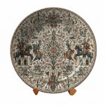Decorative plate with intricate designs on a stand against a neutral background