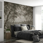 Modern bedroom with a large wall mural of trees and a bed with gray bedding.