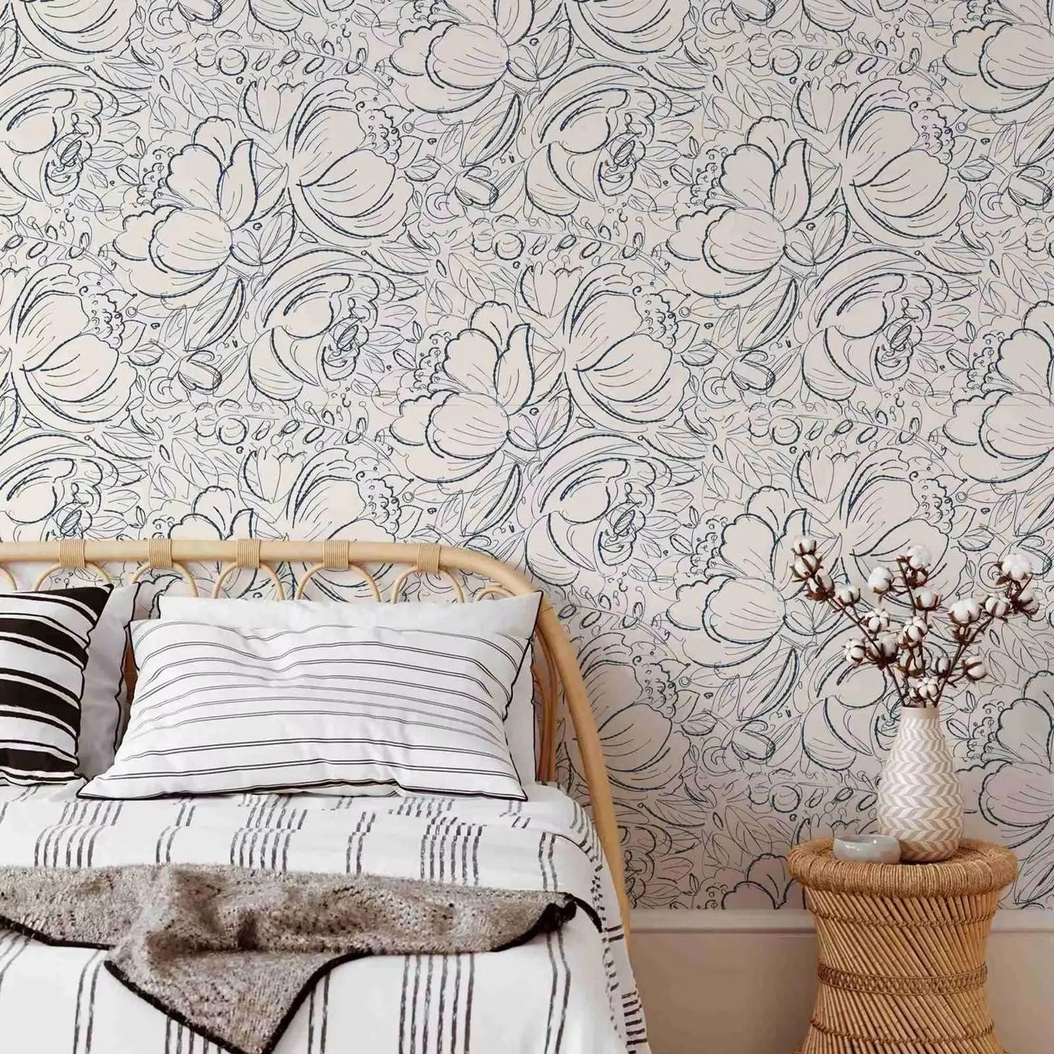 Bedroom with floral wallpaper, bed, and side table.