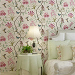 Decorative bedroom with floral wallpaper, lamp, and bed.