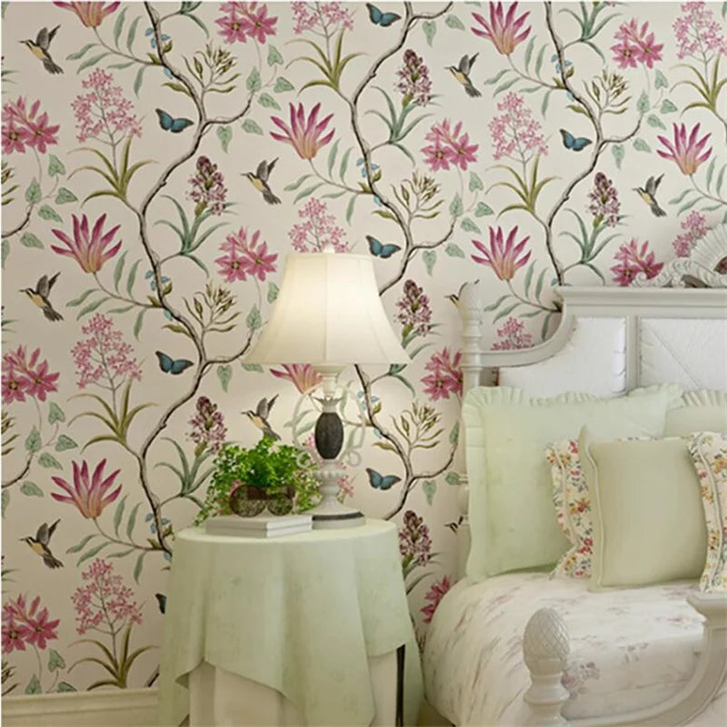 Decorative bedroom with floral wallpaper, lamp, and bed.