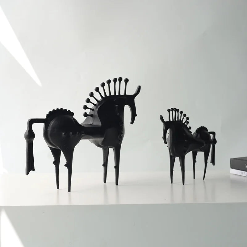 Black horse-shaped chairs on a white surface with a white background