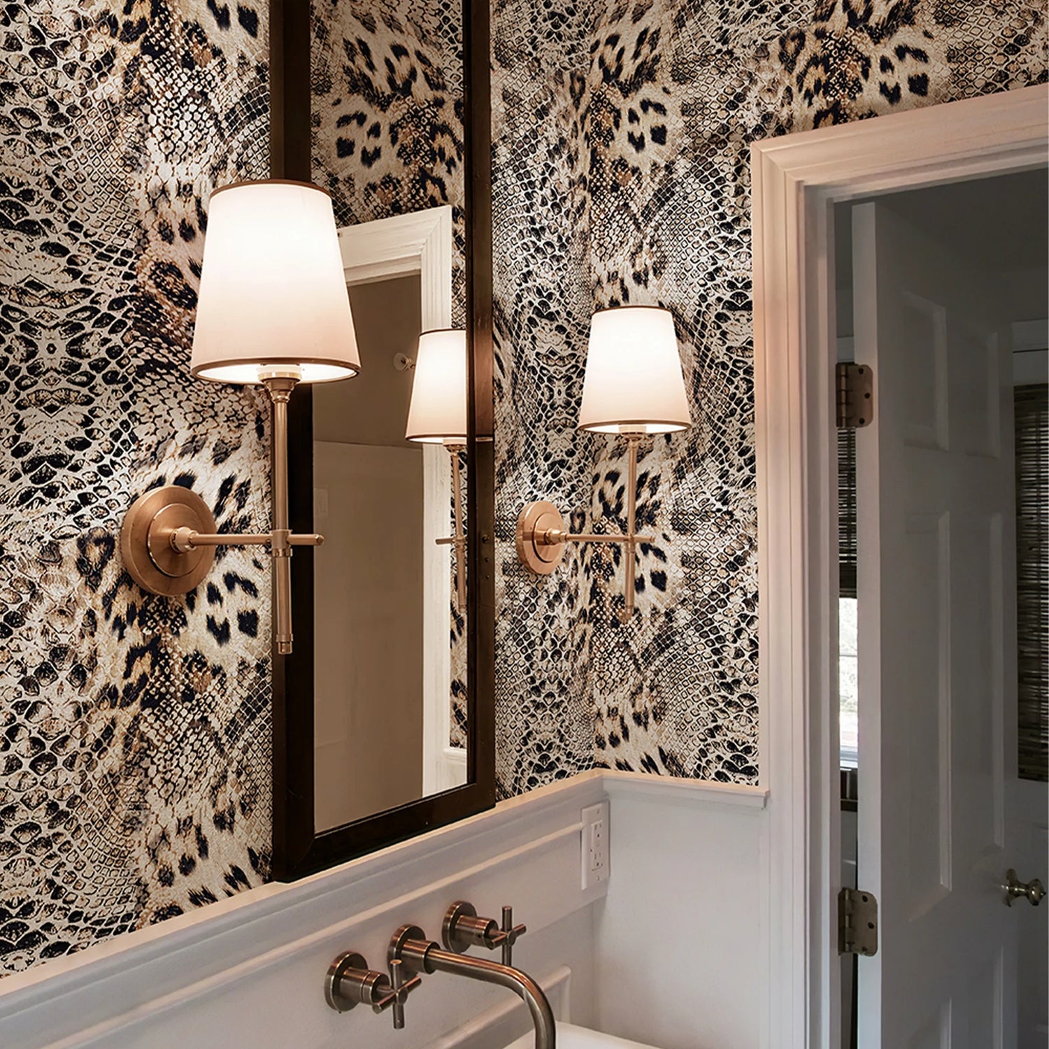 Bathroom with patterned wallpaper, mirror, and wall lights.