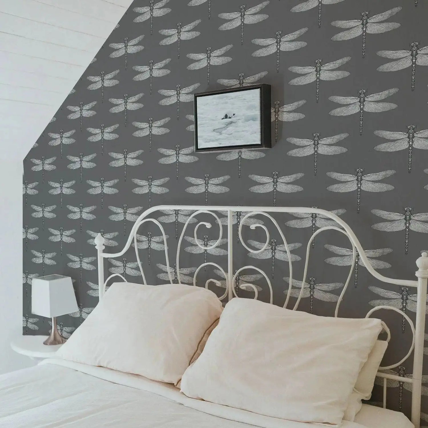 Bedroom with dragonfly-patterned wallpaper and a white metal bed frame.