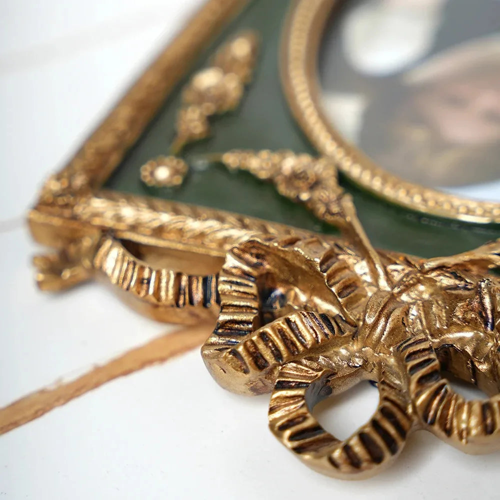 Decorative gold mirror with intricate design on a white background