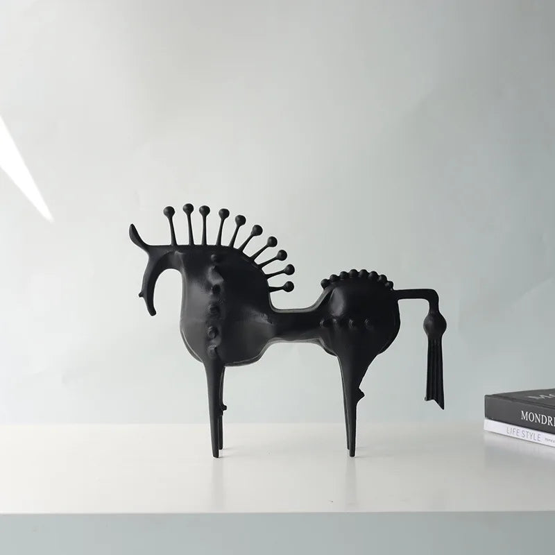 Black horse sculpture on a white surface with a white wall background