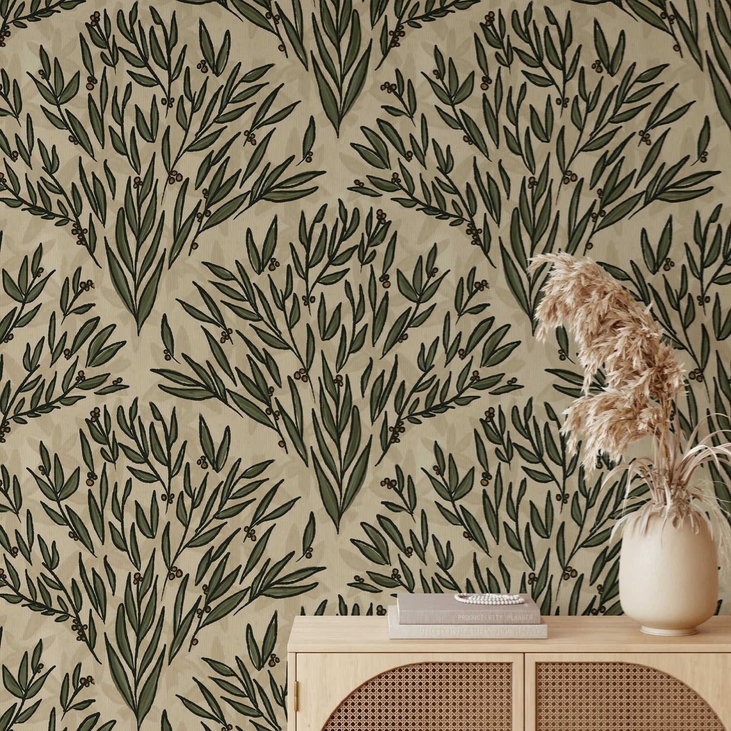 Wallpaper with green leaf pattern on beige background, with a vase and books on a wooden surface.