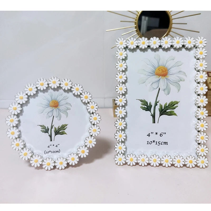 Two decorative photo frames with daisy designs on a light background