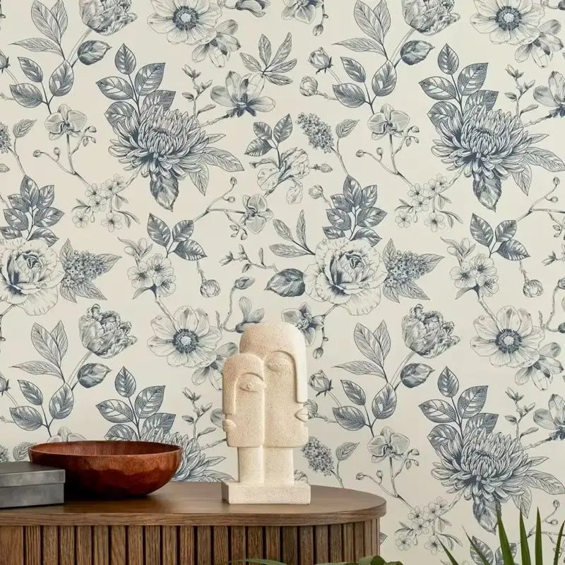 Decorative wallpaper with floral pattern, wooden bowl, and sculpture on a table.