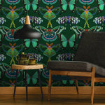 Room interior with a green butterfly-patterned wall, black chair, wooden table, and decorative items.