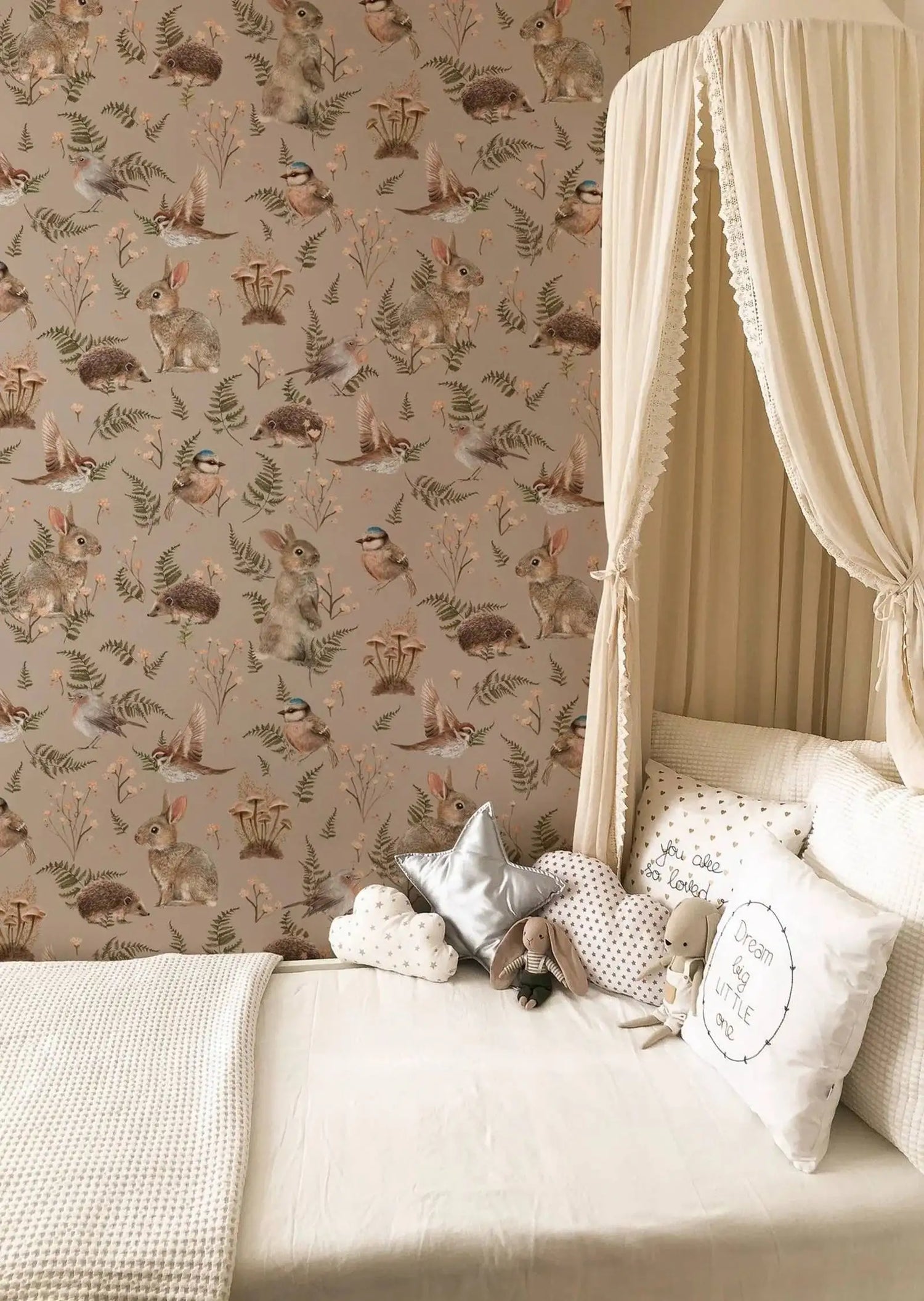 Bedroom with animal-themed wallpaper and decorative pillows on a bed.