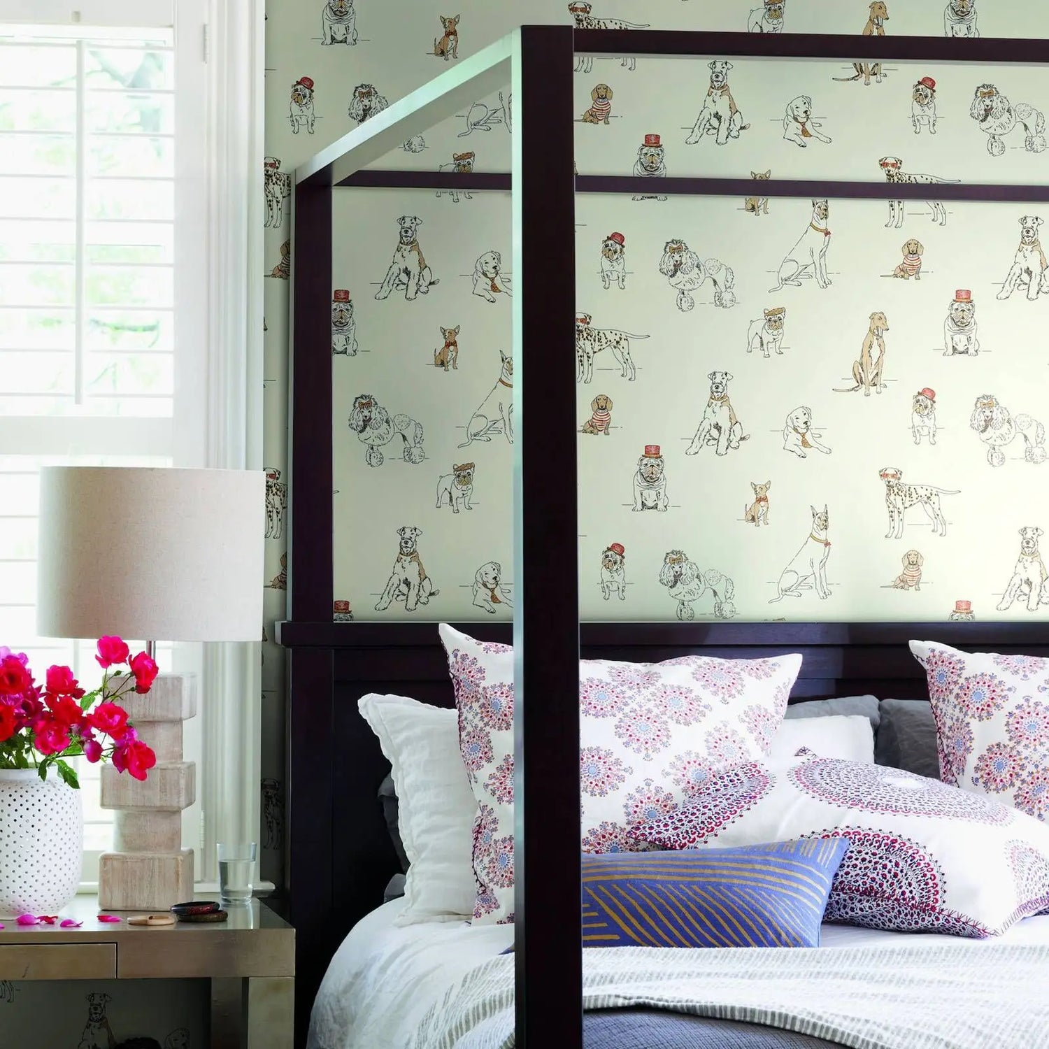 Bedroom with a bed featuring patterned headboard and pillows, next to a window with blinds.
