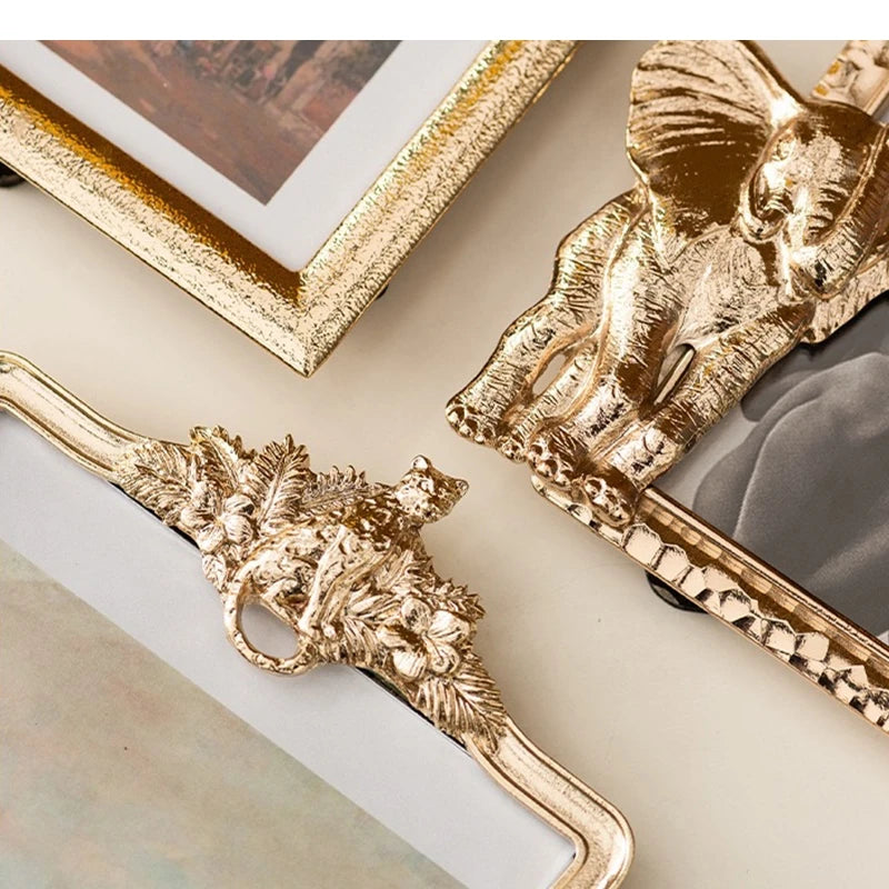 Gold decorative frames with intricate designs on a neutral background