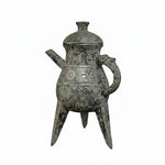Bronze teapot with intricate designs on a black background