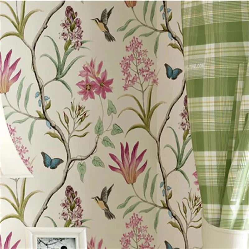 Floral wallpaper with pink flowers and green leaves, next to a green plaid fabric.
