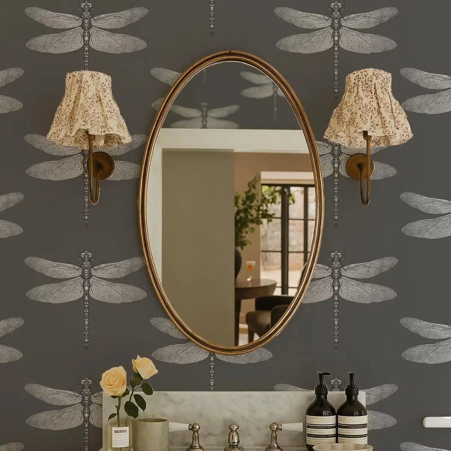 Oval mirror on a wall with dragonfly patterns and decorative lights.