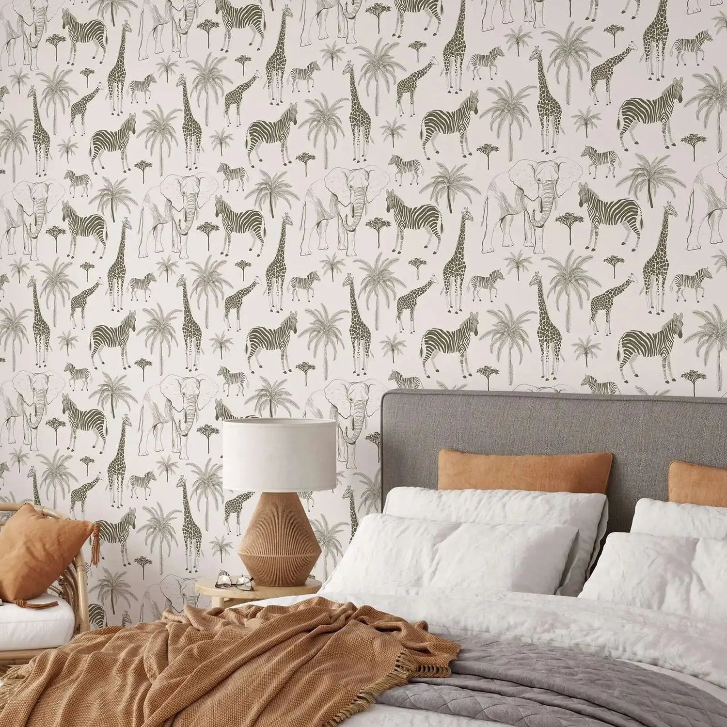 Bedroom with zebra and giraffe patterned wallpaper, bed with brown and gray bedding, and lamp.