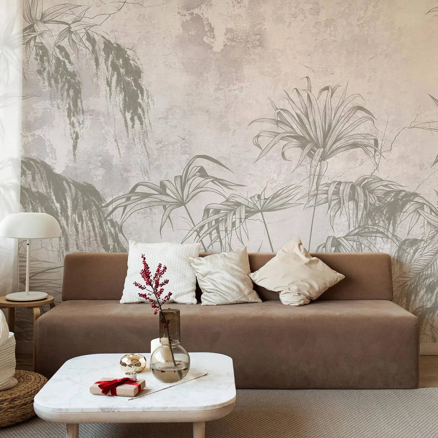 Living room with a brown sofa, decorative pillows, and a coffee table against a wall with palm leaf pattern.