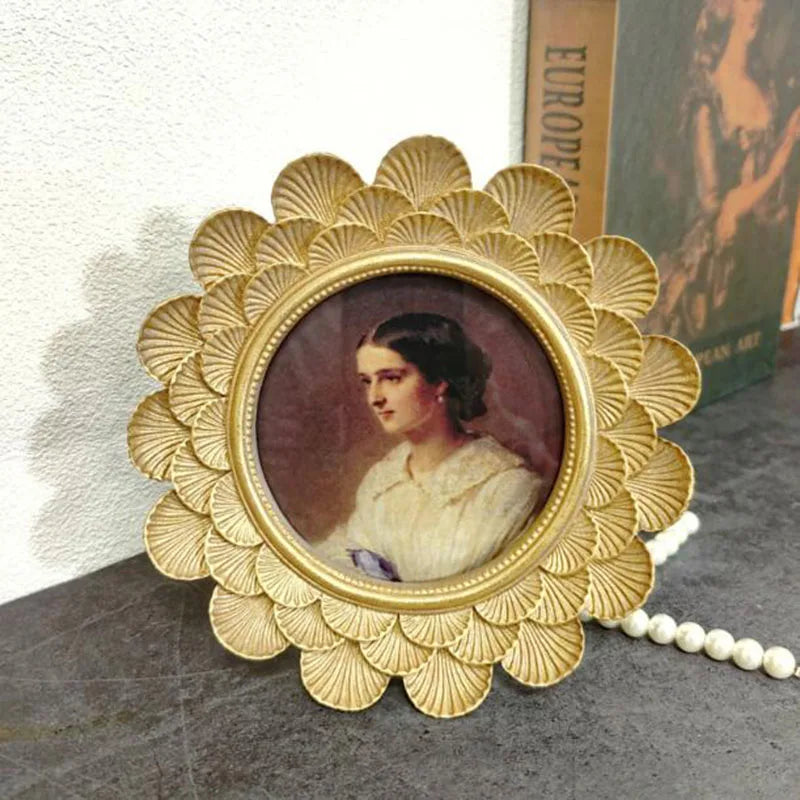 Decorative gold frame with a portrait of a woman on a textured surface.