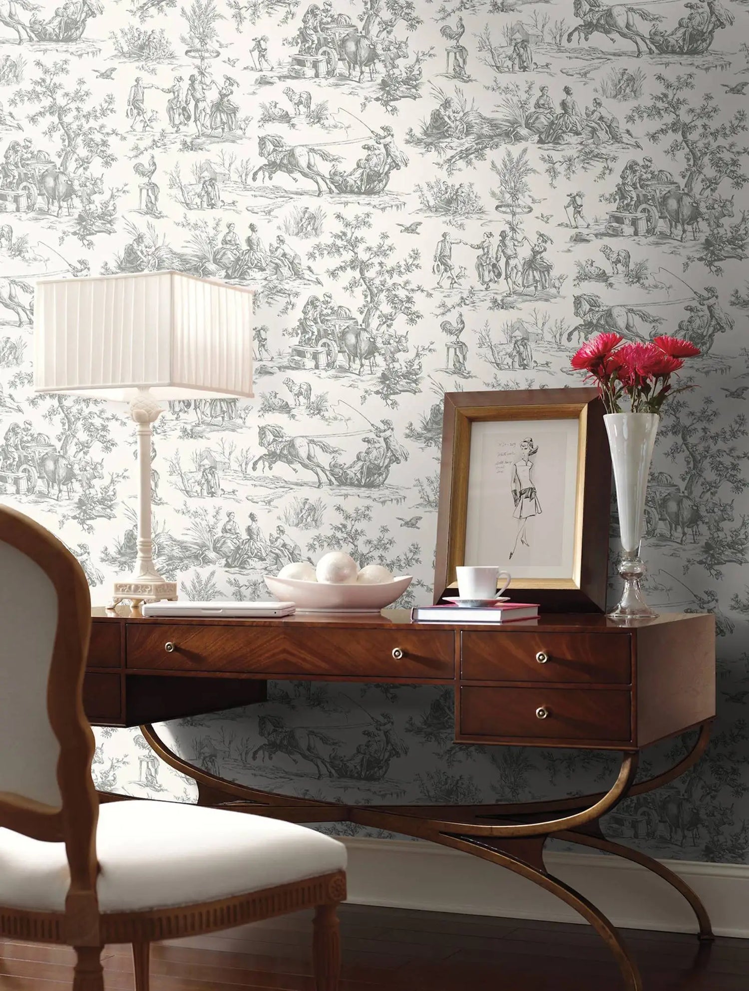 Wooden desk with decorative items against a patterned wallpaper wall.