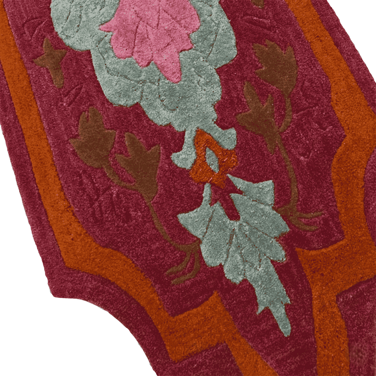 Close-up of a floral patterned rug with red, green, and brown colors.