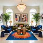 Modern living room with a colorful rug, blue chairs, and a green sofa.