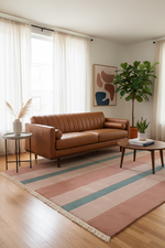 Living room with a brown leather sofa, striped rug, and decorative elements.