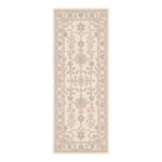A long rectangular area rug with a traditional floral and geometric pattern in soft blush pink and gray on a cream background.