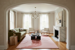 Living room with a green sofa, coffee table, and pink rug.