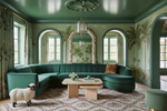 Luxurious living room with green walls, a curved green sofa, and decorative elements.