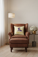 A cream throw pillow with a colorful graphic of a woman's profile and the text 'WHERE LOVE' in gold, styled on a beige armchair in a bright, modern living room setting.