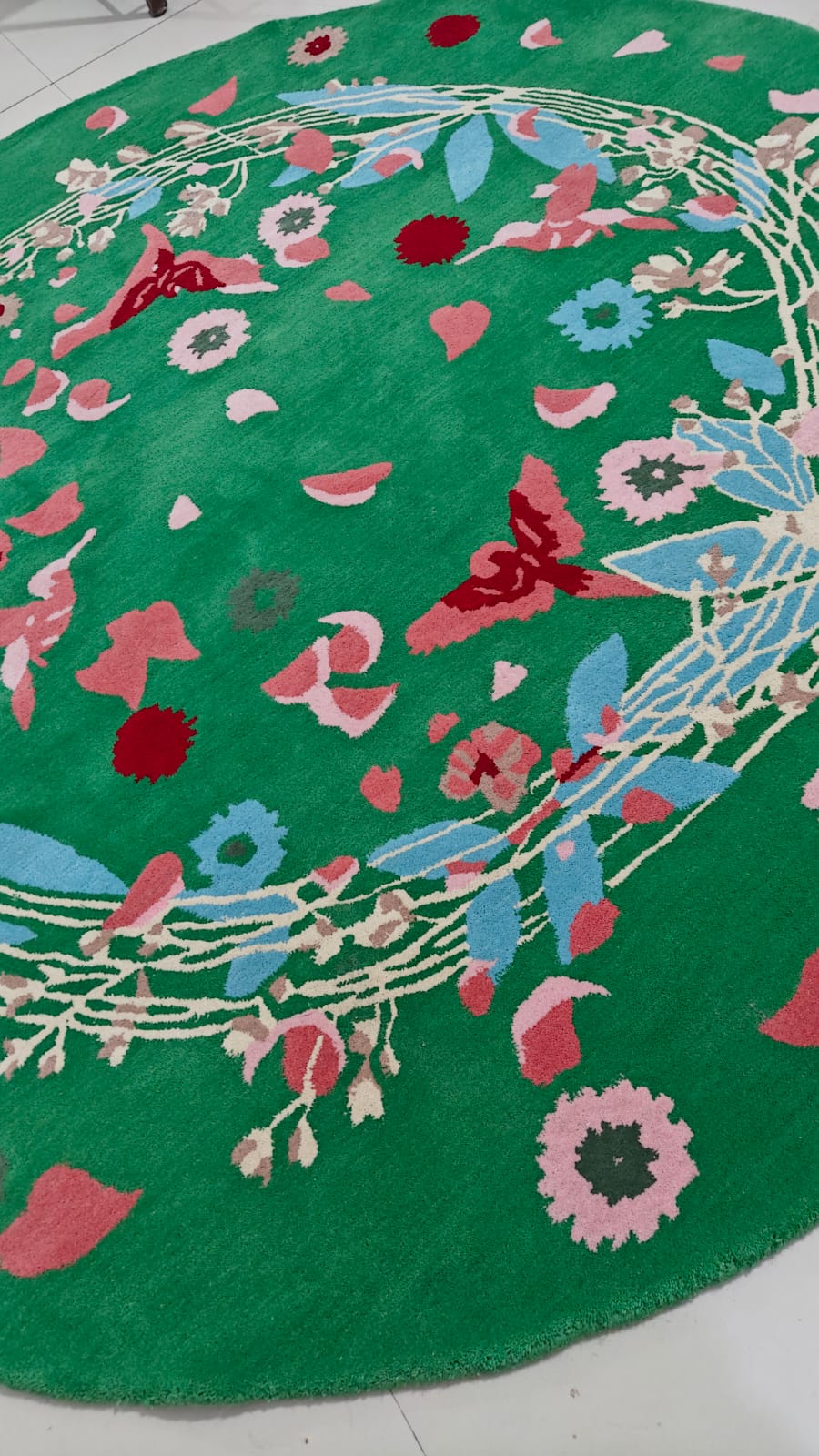 Decorative round rug with floral patterns on a green background