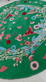 Decorative round rug with floral patterns on a green background