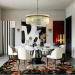 A beautifully styled living room featuring a Garden Bouquet Hand Tufted Wool Rug. This large area rug showcases vibrant floral designs, adding elegance to the room. The square area rug complements the modern decor with a chic dining table and chairs, perfect for a stylish living space. Ideal for those seeking floral rugs and wool rugs in an 8x10 size.