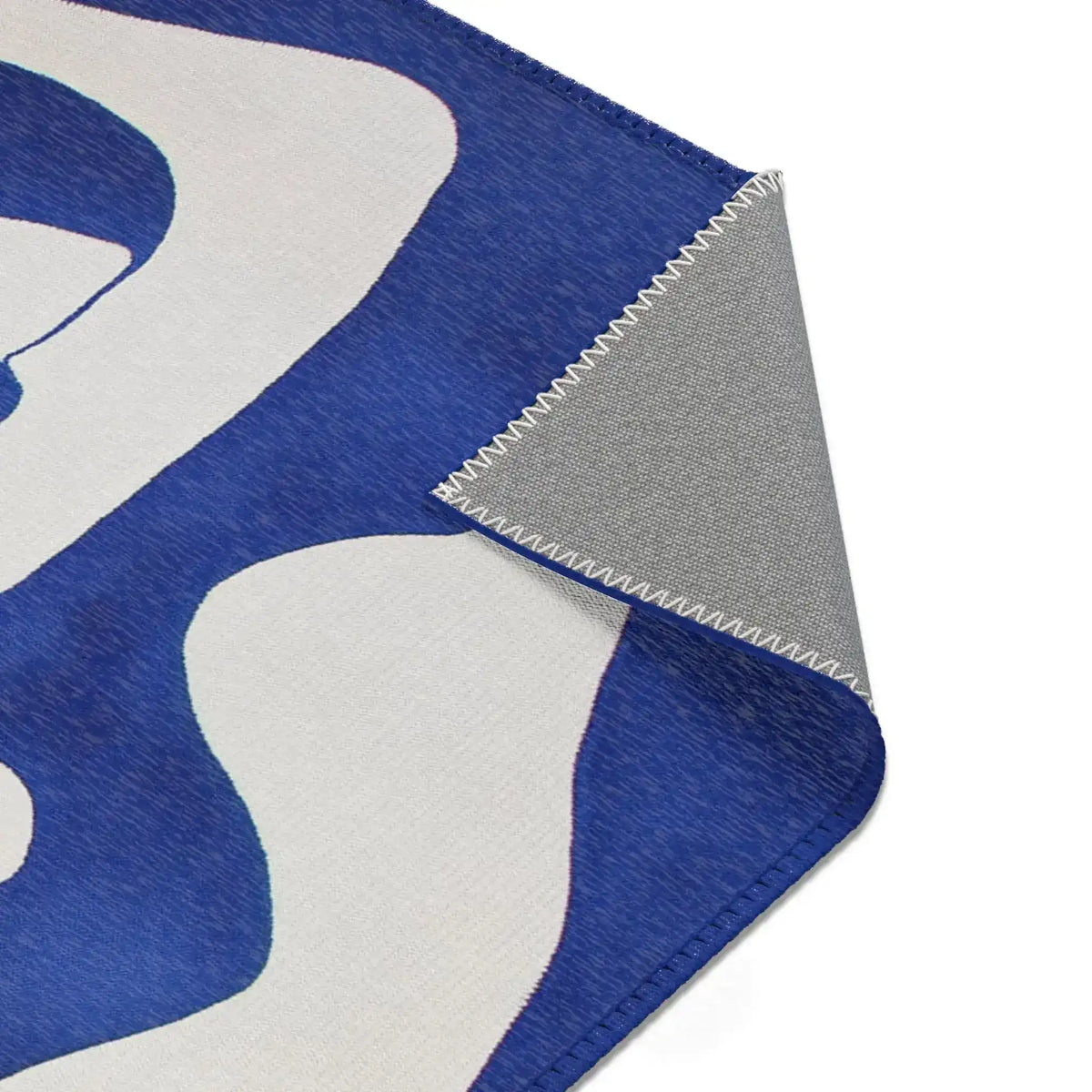 Abstract Blue and White Geometric Rug corner fold showing white organic shape on cobalt blue with grey backing folded under
