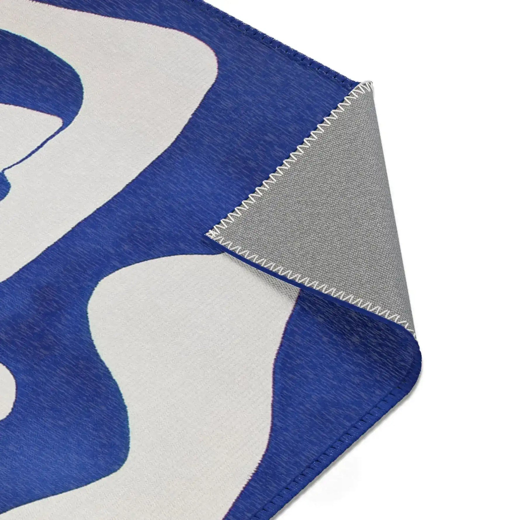 Abstract Blue and White Geometric Rug corner fold showing white organic shape on cobalt blue with grey backing folded under