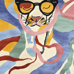 This vibrant area rug features an abstract depiction of a dog wearing sunglasses, with a playful mix of colors including blue, pink, and yellow. The hand-tufted texture adds a unique touch to any room.